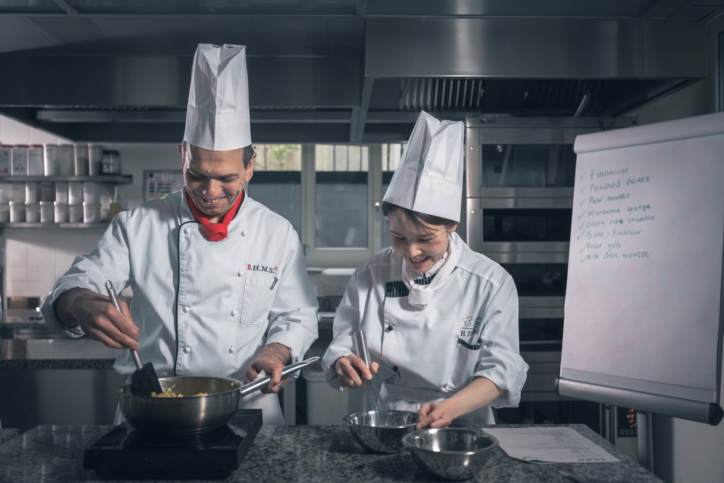 BHMS chef instructor cooking side by side with a student