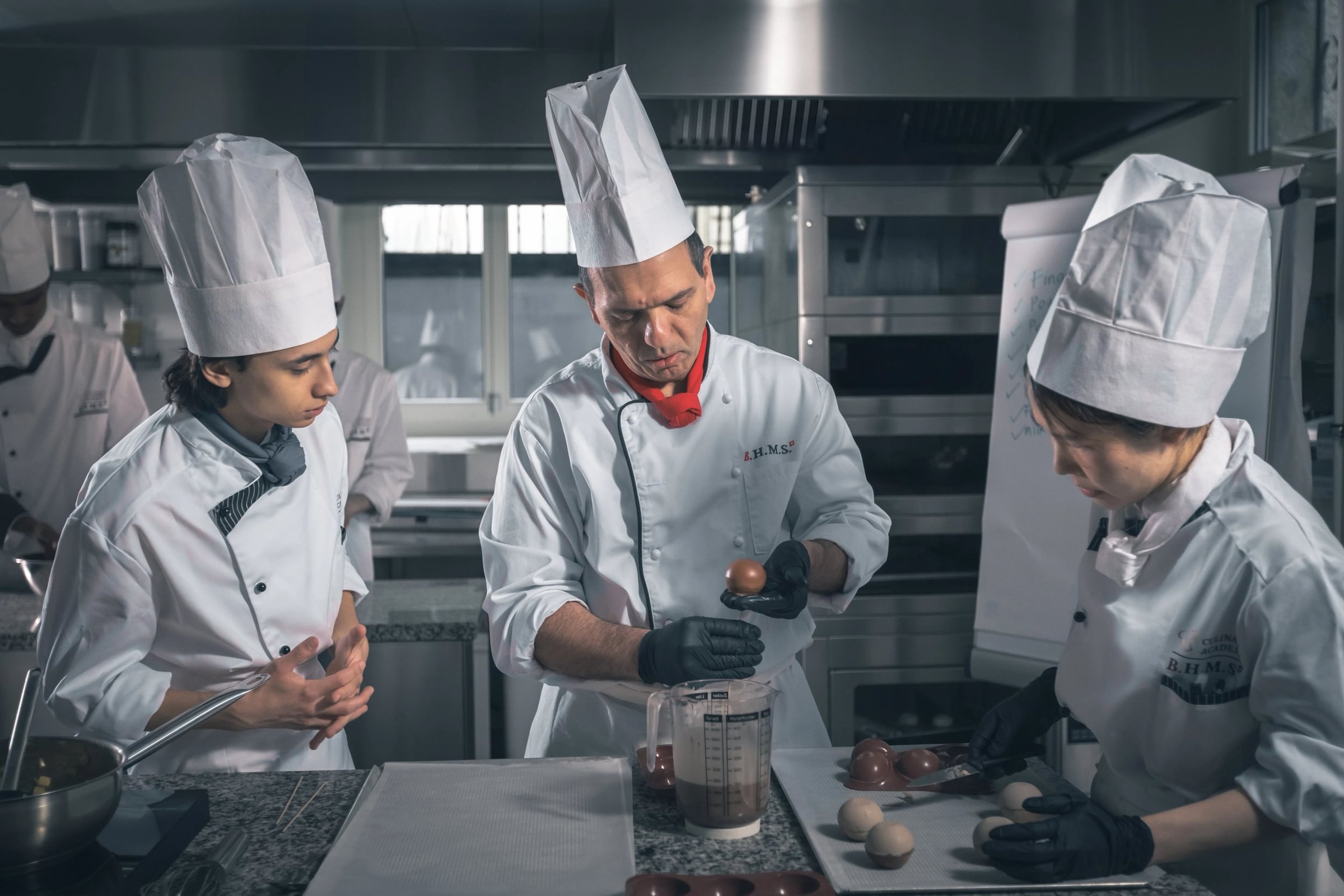 Chef demonstrating chocolate work to students in the BHMS lab