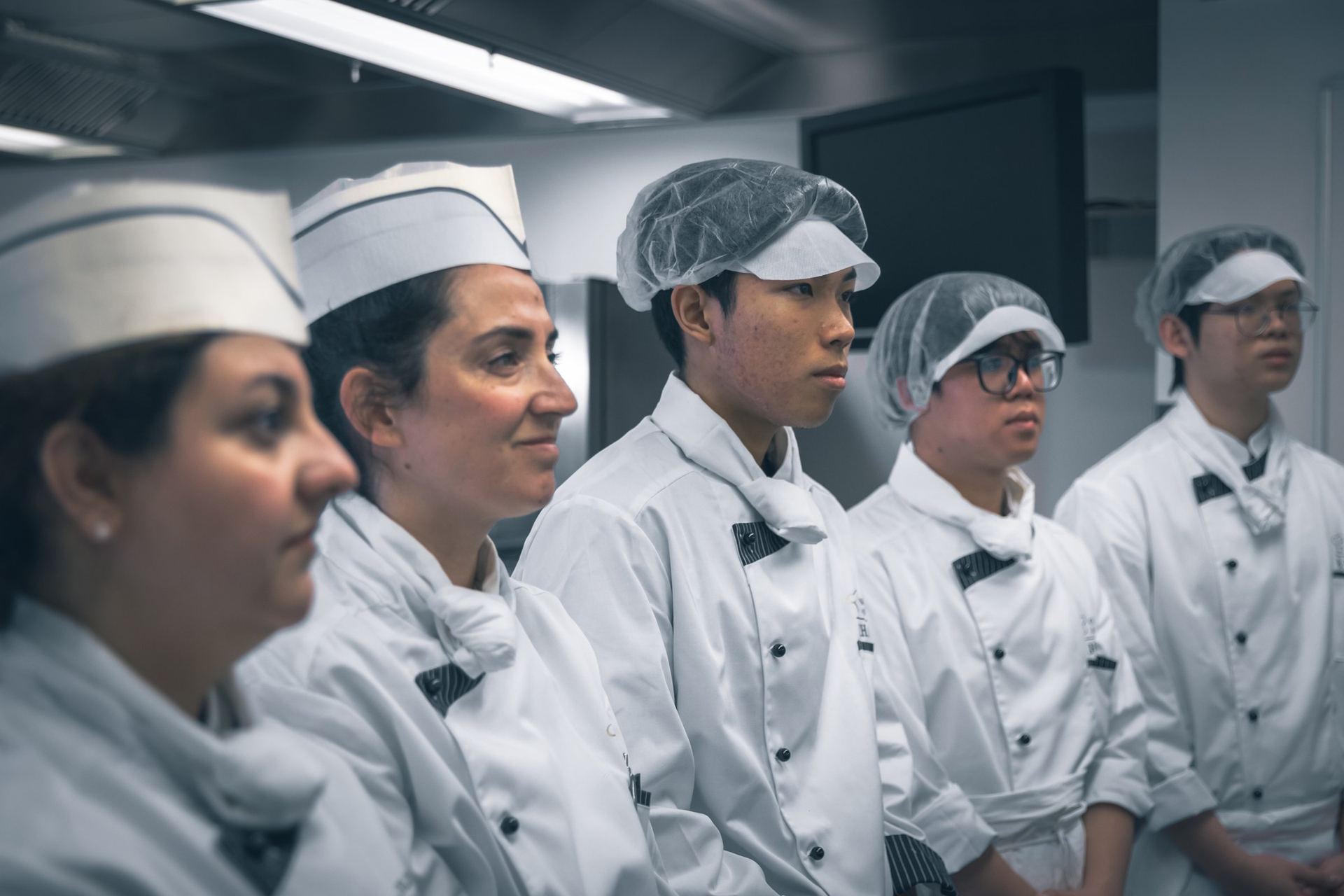 Chef instructor briefing BHMS students before kitchen service